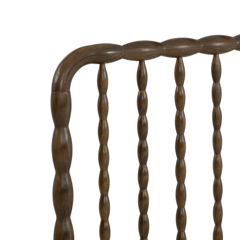 Close-up of dark walnut spindle-back wooden chair with turned spindles and curved top rail, vintage farmhouse dining chair