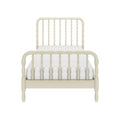 Cream painted spindle bed frame with white mattress, vintage farmhouse-style wooden headboard and footboard