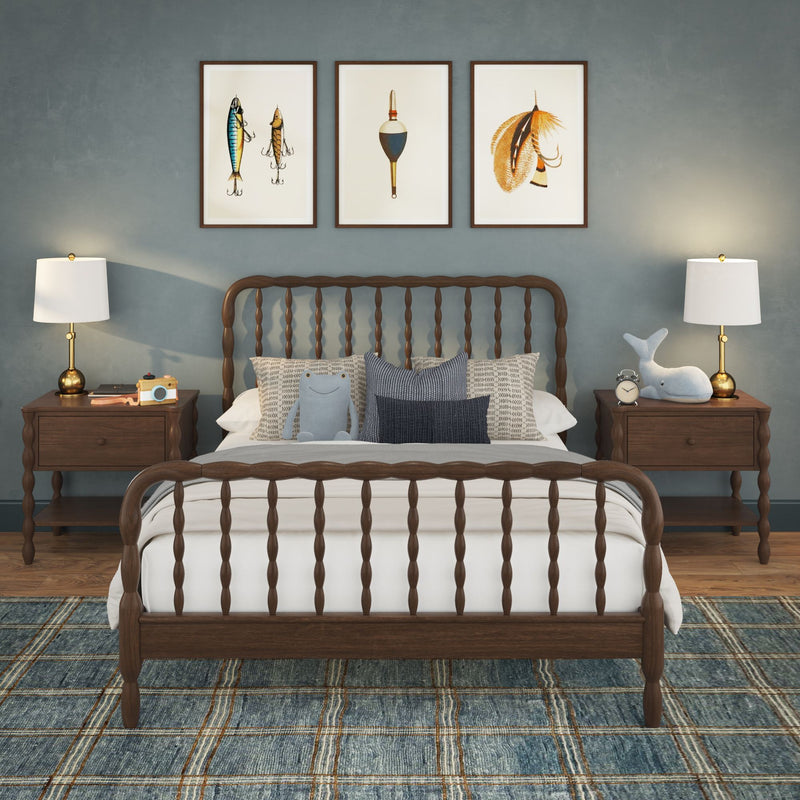 Coastal kids bedroom with dark wood spindle bed, blue accent wall, plaid rug, nightstands with lamps and nautical framed art.