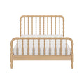 Wooden spindle bed frame in natural wood finish with carved spindles and matching footboard, white mattress — farmhouse bedroom furniture