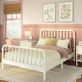 Pastel pink child's bedroom with cream spindle bed, yellow gingham bedding, scalloped wainscoting, floral framed prints and bedside lamp