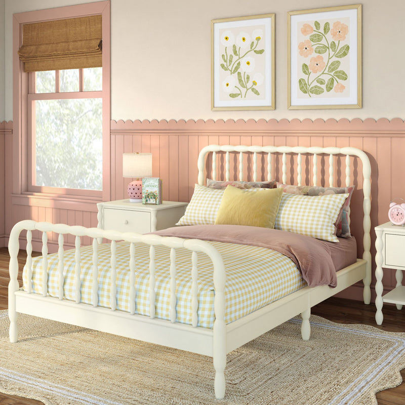 Pastel pink child's bedroom with cream spindle bed, yellow gingham bedding, scalloped wainscoting, floral framed prints and bedside lamp