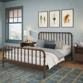 Coastal farmhouse bedroom interior with wooden spindle bed, blue plaid area rug, gray bedding, wooden nightstands, brass lamp and nautical framed art