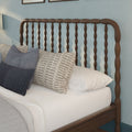 Solid wood spindle headboard with white linens and blue and beige textured throw pillows in modern coastal farmhouse bedroom