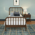 Children's bedroom with vintage wooden spindle bed, plush frog toy, navy textured pillows, nightstand with lamp and alarm clock, teal accent wall and blue patterned rug