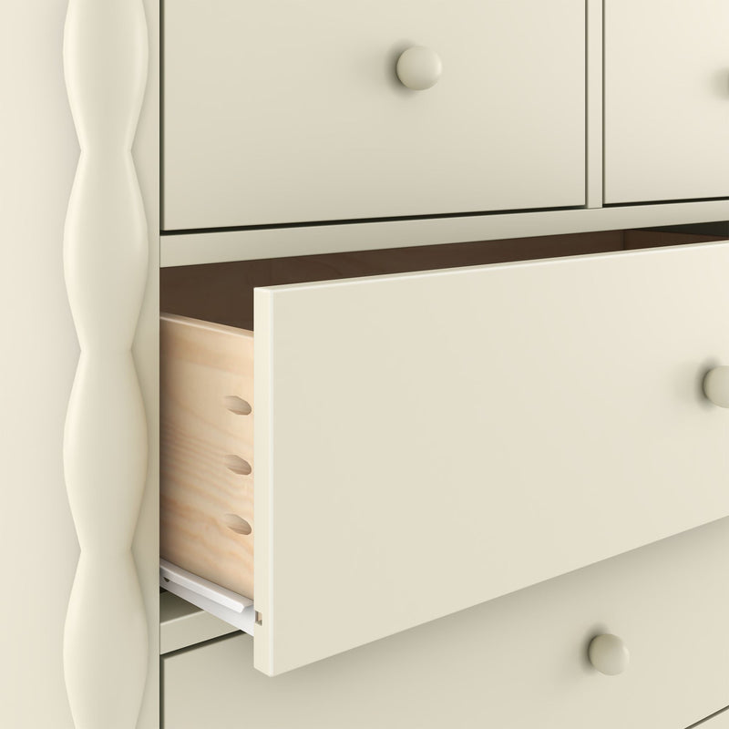 Close-up of cream-painted wooden dresser with a partially open drawer, round knob, visible dovetail joinery and natural wood interior — bedroom storage dresser detail