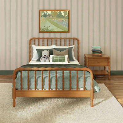 Cozy children's bedroom with wooden spindle bed, green bedding and pillows, teddy bear on the bed, striped wallpaper, wooden nightstand with stacked books and framed artwork