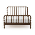 Dark walnut spindle bed frame with turned spindles and rounded headboard over white mattress, vintage farmhouse wooden bed product photo