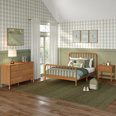 Cozy children's bedroom with green wainscoting and beige gingham wallpaper, spindle wood bed, natural wood dresser, soft green bedding, teddy and backpack