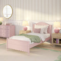 Pastel pink girl's bedroom with scalloped twin bed, green throw, pink bedside lamps, pink dresser, round mirror and floral striped wallpaper
