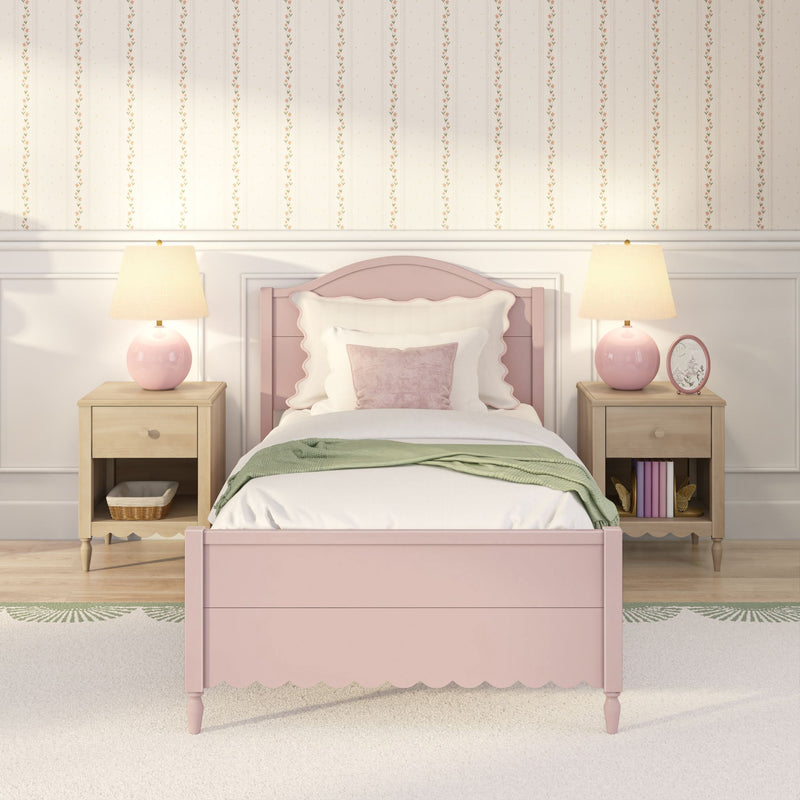 Pastel pink bed with scalloped headboard, floral striped wallpaper, wooden nightstands and pink lamps in a cozy kids' bedroom