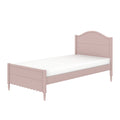 Pink twin wooden bed frame with curved headboard, scalloped footboard and turned legs, single bed with white mattress.