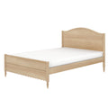 Light natural wood bed frame with white mattress, curved headboard, scalloped footboard and turned legs, cottage farmhouse style