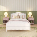 Girls bedroom decor: white wooden bed with pastel pink bedding, floral throw pillows and teddy bear, matching pink nightstands with lamps, green wainscoting and floral wallpaper