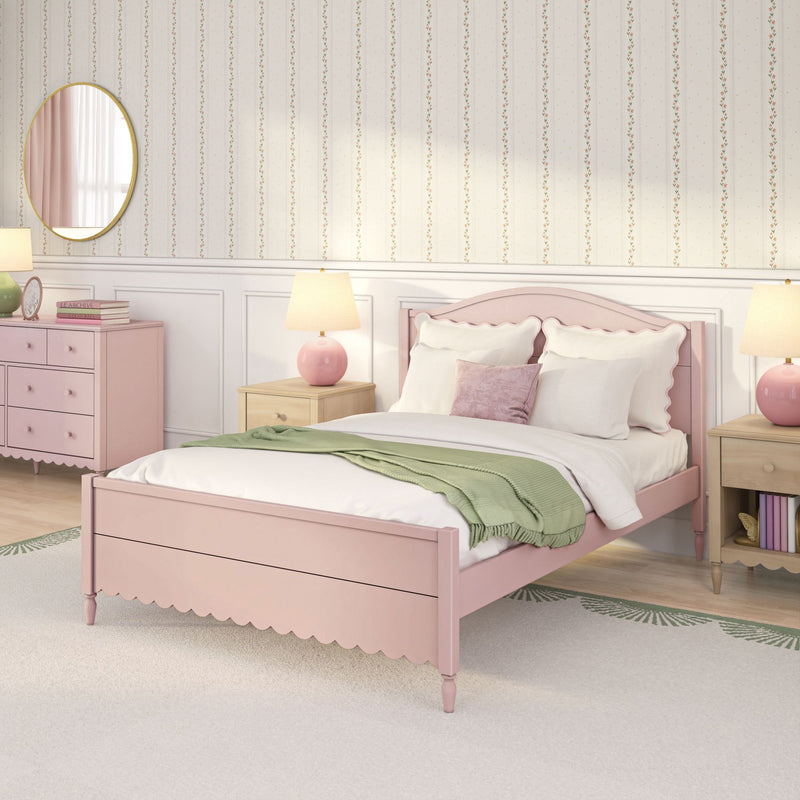 Pastel pink bedroom interior with scalloped wooden bed, white bedding and pink pillows, green throw blanket, bedside lamps, pink dresser, round mirror and floral striped wallpaper