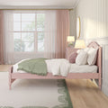Pink twin bed in a girls' pastel bedroom with green throw blanket, blush curtains, large window, round mirror and bedside lamps — modern kids' room decor