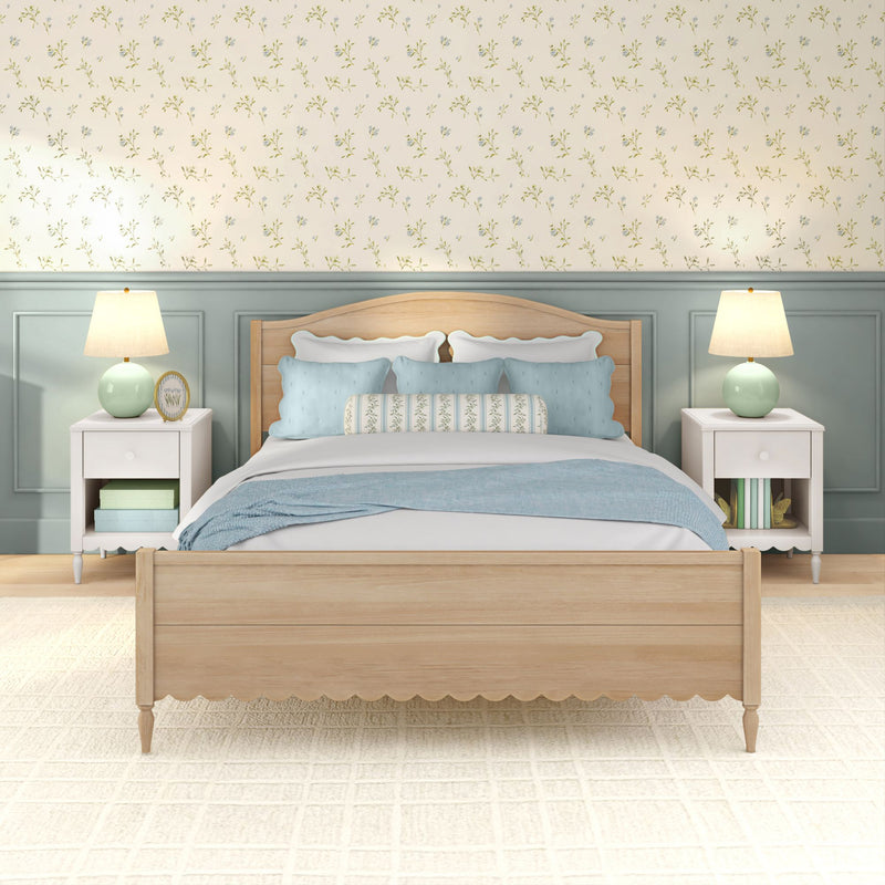 Cozy farmhouse bedroom with light wood bed frame, pastel blue pillows and throw, floral wallpaper, mint bedside lamps and white nightstands