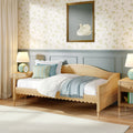 Cozy cottage bedroom interior with light wood single bed, pastel bedding and throw, floral wallpaper, framed swan painting and bedside lamp