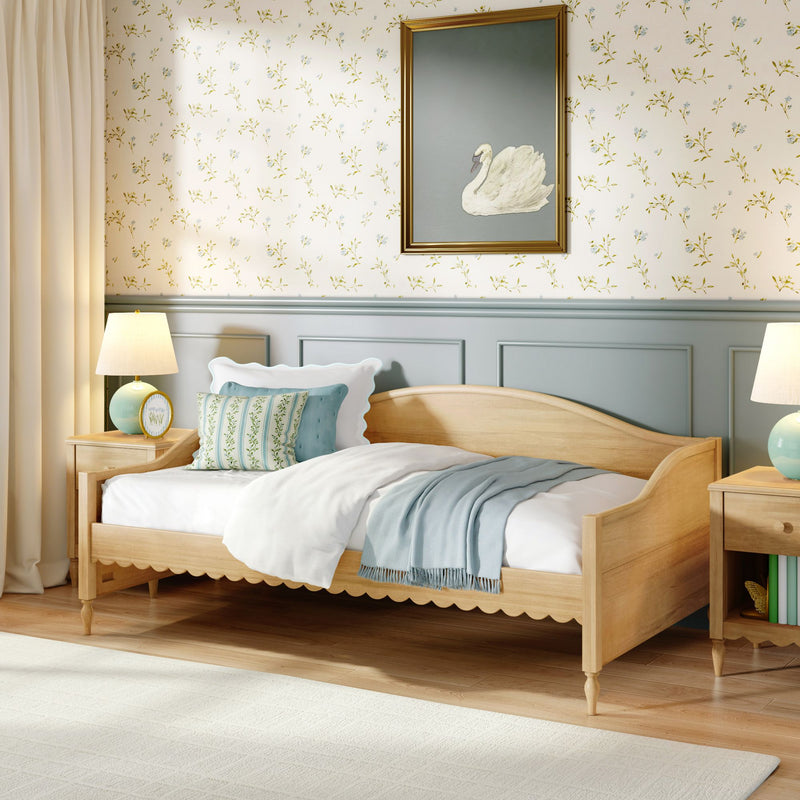 Cozy cottage bedroom interior with light wood single bed, pastel bedding and throw, floral wallpaper, framed swan painting and bedside lamp