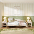 Cozy pastel kids' bedroom with floral wallpaper, green wainscoting, white daybed, plush teddy bear and bedside lamps