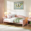 Pastel pink girls' bedroom with scalloped daybed, soft white bedding and blush pillows, green throw, framed butterfly wall art and pink bedside lamp, kids bedroom decor