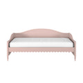 Pink wooden twin daybed with curved headboard, scalloped trim, turned legs and white mattress, vintage-style children's bed