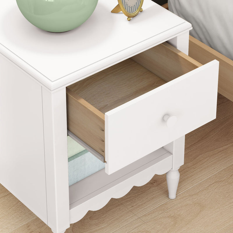 White wooden bedside nightstand with open drawer, light-wood interior and lower shelf storage, decorative lamp and clock on top
