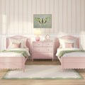 Pastel pink girls' bedroom with scalloped twin beds, matching pink dresser and lamp, butterfly wall art, floral wallpaper and green-accented throws