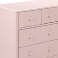 Blush pink wooden dresser close-up with round knobs, modern nursery bedroom chest of drawers image