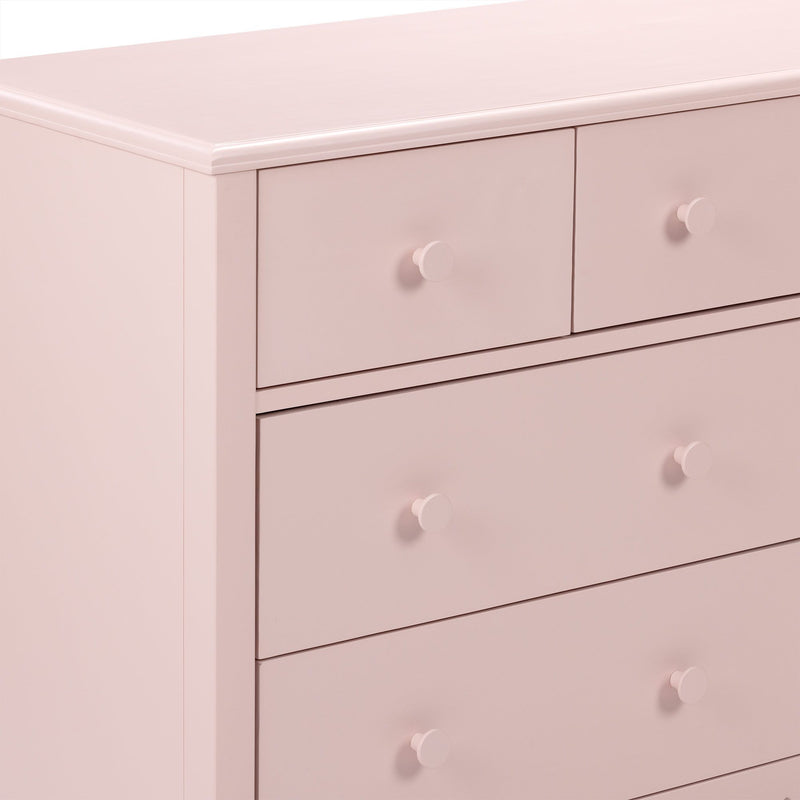 Blush pink wooden dresser close-up with round knobs, modern nursery bedroom chest of drawers image