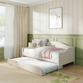 Pastel children's bedroom with daybed trundle, pink throw, floral pillows, teddy bear, cream curtains and green wainscoting