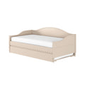 Beige wooden daybed with curved headboard, scalloped apron and pull-out trundle drawer, white mattress — farmhouse-style storage bed