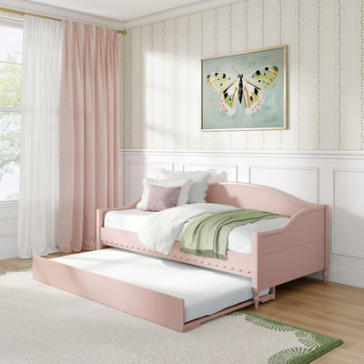 Pink daybed with trundle in pastel girls' bedroom with butterfly wall art, blush curtains, floral striped wallpaper and green throw blanket