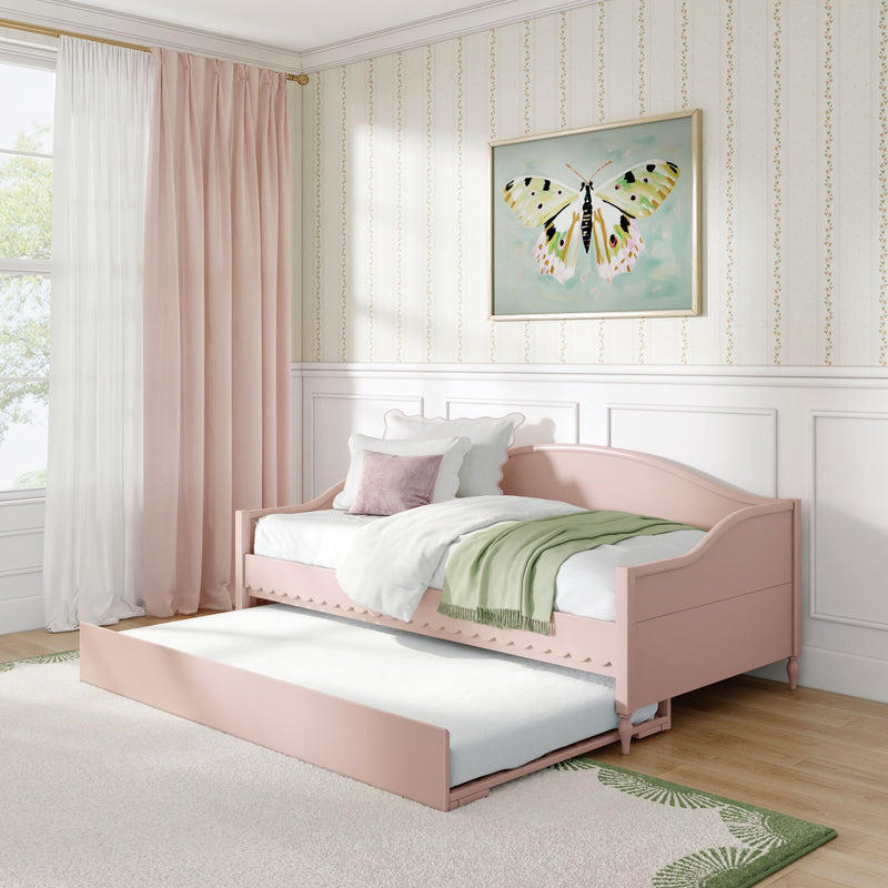 Pink daybed with trundle in pastel girls' bedroom with butterfly wall art, blush curtains, floral striped wallpaper and green throw blanket