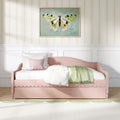 Pink daybed with white bedding and green throw in a pastel girl's bedroom featuring framed butterfly wall art and floral striped wallpaper