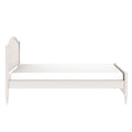 White wooden twin bed frame with arched headboard and low footboard, mattress on platform, farmhouse-style bedroom furniture on white background