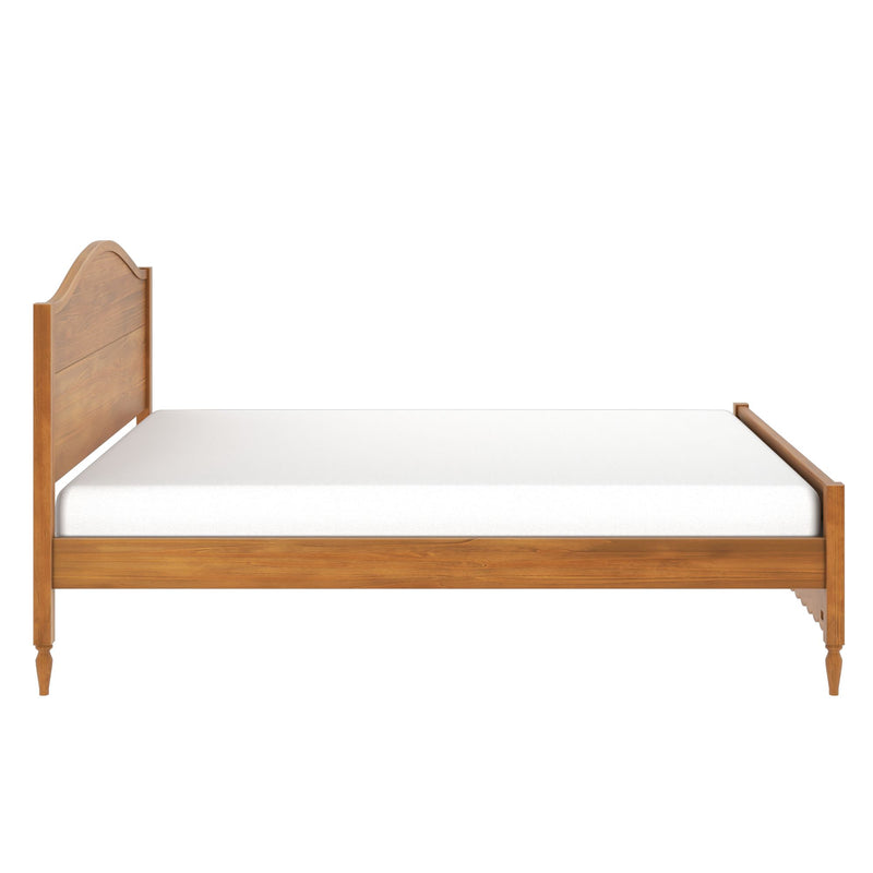 Solid wood farmhouse bed frame with curved headboard and turned legs, white mattress isolated on white background