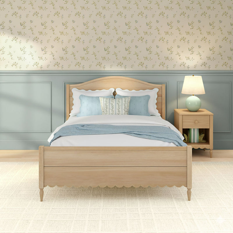 Cozy cottage bedroom with light wood bed, blue accent pillows, floral wallpaper, pale-blue wainscoting and bedside lamp