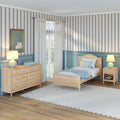 Cozy coastal-style twin bedroom with light wood bed and dresser, teal wainscoting, vertical blue-striped wallpaper, sheer white curtains, bedside lamps, and swan artwork
