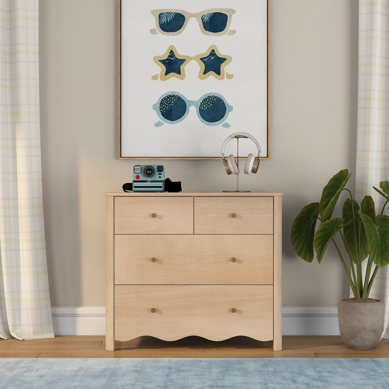Light wood dresser with retro instant camera, gold headphone stand, framed sunglasses wall art, neutral plaid curtains and potted plant