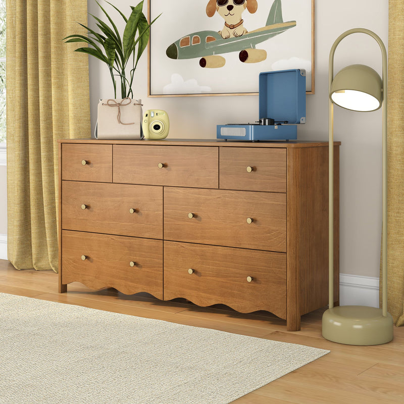 Mid-century modern multi-drawer wood dresser in a children's nursery styled with a blue record player, yellow instant camera, potted plant, dog airplane wall art, mustard curtains and modern floor lamp on light hardwood floor