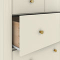 Minimalist cream dresser with gold knobs and partially open wooden drawer on metal slides, modern bedroom storage cabinet