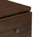 Close-up of dark walnut wooden drawer corner with rounded edge and brushed brass knob