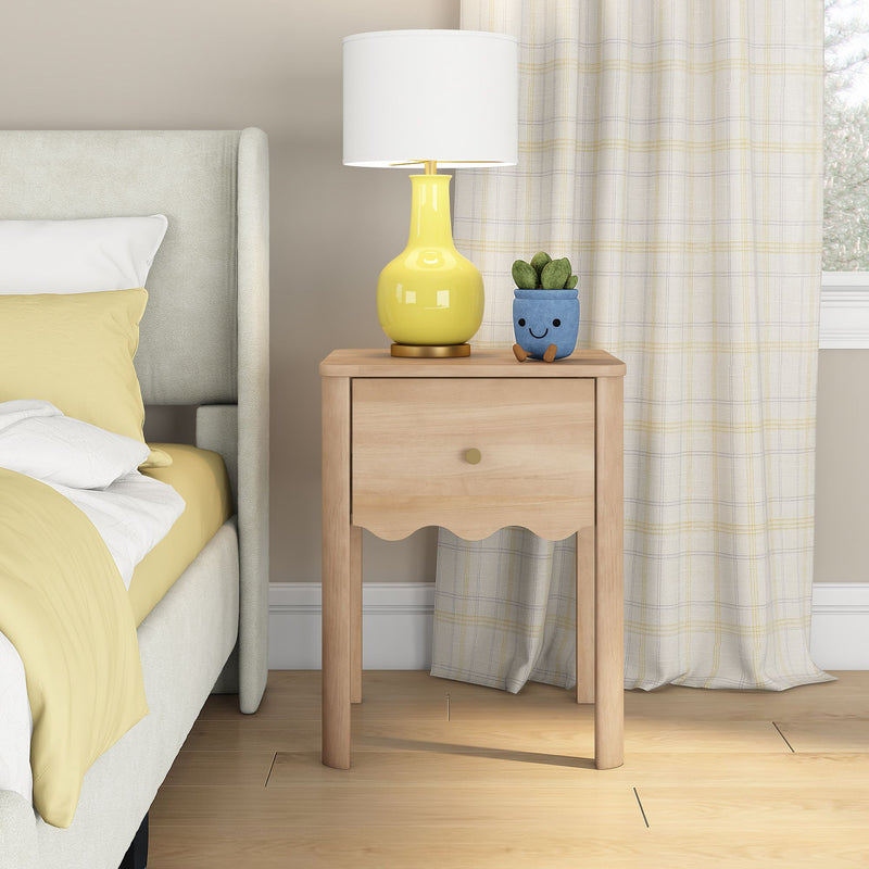 Light wood nightstand with yellow ceramic table lamp and cute blue potted succulent beside upholstered bed with yellow bedding — modern cozy bedroom decor