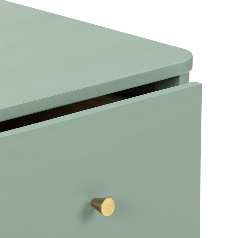 Close-up of mint green wooden dresser drawer with matte finish and brass cone knob, modern nightstand detail