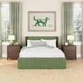Green upholstered bed in cozy modern bedroom with green curtains, wooden nightstands, bedside lamps and framed dog artwork