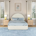Modern kids bedroom with cream arched upholstered bed, light blue bedding, light wood nightstands, yellow bedside lamps, striped curtains, framed mouse wall art and plush blue area rug