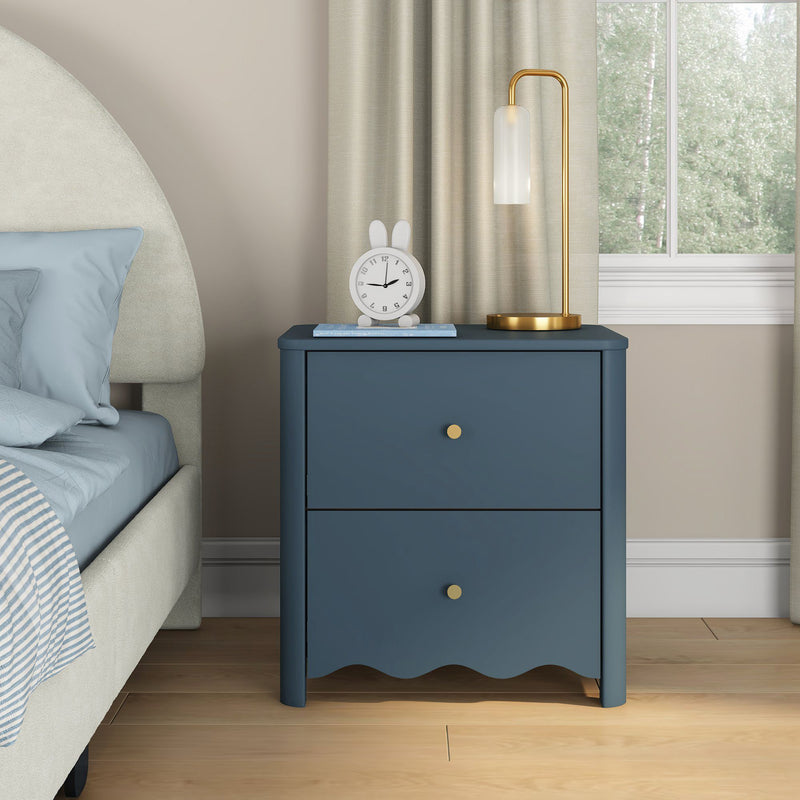 Blue two-drawer bedside table with gold knobs, brass lamp and white bunny alarm clock in modern bedroom decor