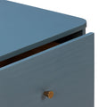 Close-up of matte blue painted dresser drawer partially open with brass cone knob, modern minimalist nightstand detail
