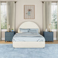 Modern children's bedroom with cream round upholstered headboard, light blue bedding, navy nightstands, gold lamps, beige curtains and mouse wall art